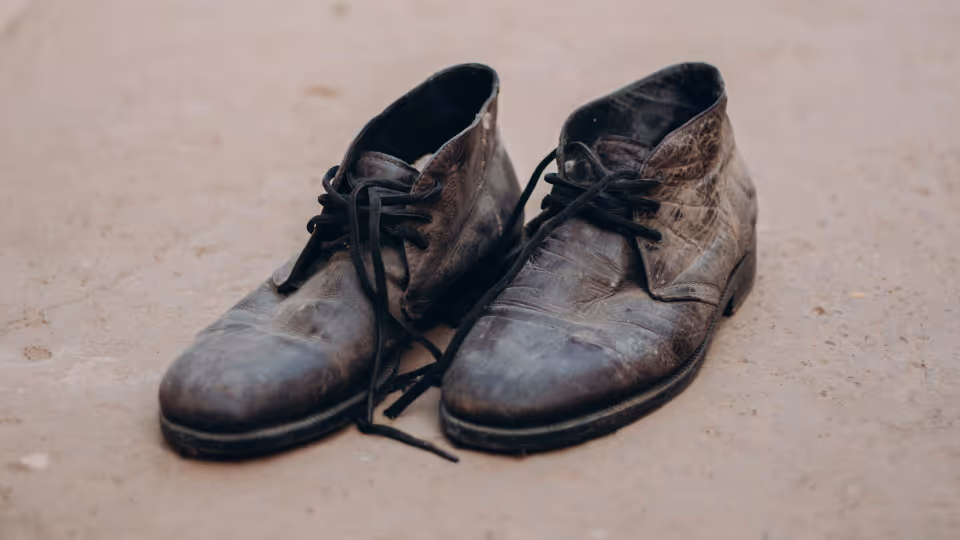 Close up of an old pair of shoes with holes in them